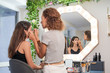 © PHILIPPE DEGROOTE/ADDICTIVE STOCK - Side view of stylist doing makeup for lady in chair in light stylish salon