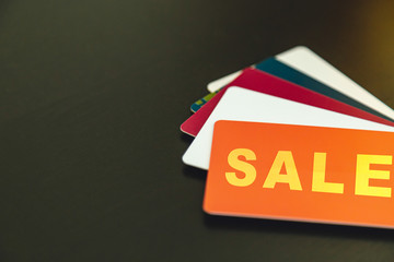 plastic discount cards and and the word sale on a black background