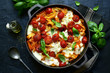 Pasta casserole with tomatoes and mozzarella cheese in a cast iron pan. Top view with copy space.