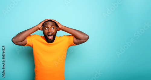 Fotomural Amazed and shocked expression of a boy over cyan background