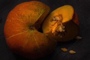 Canvas Print - Closeup still life shot of a sliced pumpkin on black background