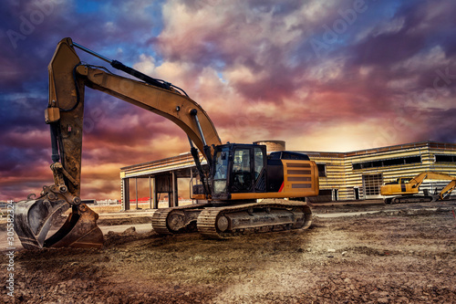 Cuadros en Lienzo Excavating machinery at the construction site, sunset in background