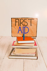 Conceptual hand writing showing First Aid. Concept meaning Practise of healing small cuts that no need for medical training pile stacked books notebook pin color reminder white wooden