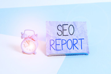 Fototapete - Handwriting text writing Seo Report. Conceptual photo notifying on how website is performing in search engine results Mini size alarm clock beside a Paper sheet placed tilted on pastel backdrop