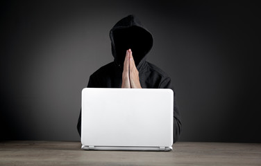 Hacker with laptop. Computer crime.