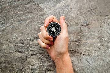 Wall Mural - Choose direction concept. Compass in hand on grey background top view copy space