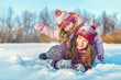 © sborisov - Little girl and her mother playing outdoors at sunny winter day. Active winter holydays concept.