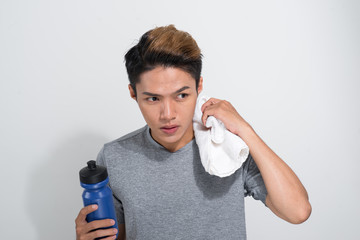 Wall Mural - young Asian fitness man holding towel and bottle with water isolated on a white background