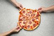 © New Africa - People taking slices of tasty pepperoni pizza at light grey table, top view