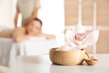 Canvas Print - Bowl with sea salt and orchid flower on white table in spa salon. Space for text