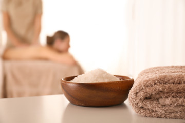 Wall Mural - Bowl with sea salt on white table in spa salon