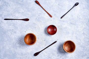 Wall Mural - Eco-friendly wooden bowls, spoons on blue background, flat lay with copy space, top view.