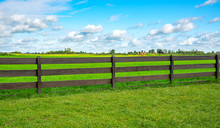 Green Fence Field And A Blue Sky. Pastures Out Of Town.