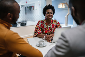traditional dressed black african business woman financial bank adviser in meeting with customer