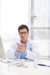 Wall Mural - Portrait of senior doctor sitting in medical office