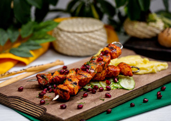 lamb kebab on skewers garnished with pomegranate and herbs