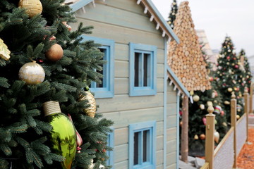 Wall Mural - Christmas trees and toy house on a winter street. New Year decorations in a city, magic of the holiday