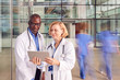© Monkey Business - Male And Female Doctors Having Informal Meeting In Modern Hospital Looking At Digital Tablet