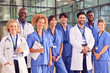 Portrait Of Smiling Medical Team Standing In Modern Hospital Building