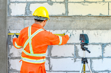 Construction workers Is using a laser level meter for wall leveling device