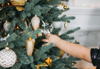 Wall Mural - Children's hand reaches for toys on Christmas tree