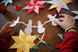Kinder basteln, falten, schneiden in der Weihnachtszeit Weihnachstern, Origami Stern und Schneemann aus buntem Papier