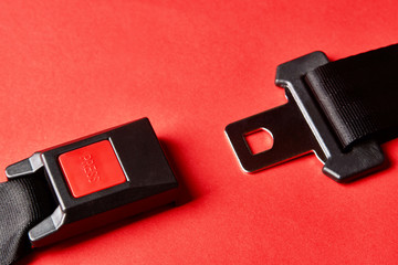 Fastened seat belt on red background with copy space, close-up