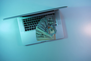 Aufkleber - Beautiful silver laptop and cash dollars banknote in the color light on a table and  background. Work night concept. Top view.
