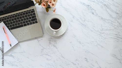 Fotomural Office desk with marble texture and laptop, pen, notebook, coffee with flower on copy space table
