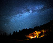 Milky way galaxy long exposure astrophotography night outdoor scene with campfire in mountains forrest. Adventure lifestyle astronomy concept. Cosmic atmosphere universe landcape.