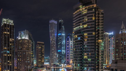  View of various skyscrapers and towers in Dubai Marina from above aerial night timelapse