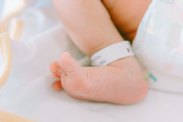 newborn baby in hospital with identification bracelet tag name