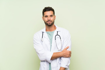 Wall Mural - Young doctor man over isolated green wall