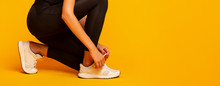Unrecognizable Lady Lacing Shoes Before Fitness Workout, Yellow Background, Panorama