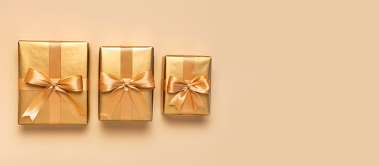 Wall Mural - Three Beautiful golden gift boxes on gold background top view Flat lay. New Year presents Festive decorations 2020 celebration. Birthday present, March 8, Merry Christmas and Happy Holidays card