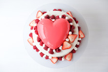 Two-tiered Mousse Cake With Red Mirror Glaze In The Shape Of A Heart On A White Background. Valentine's Day Gift. Top View.