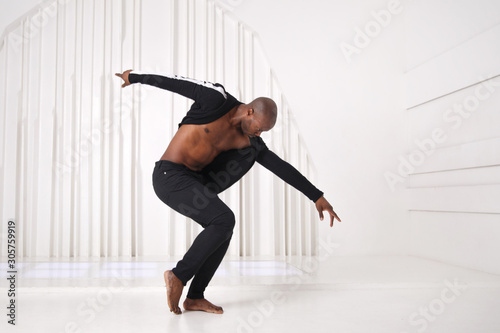 Elegant black man dancer in black clothes is dancing in a bright room Tableau sur Toile