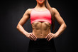 © F8  \ Suport Ukraine - Close up of fit woman's torso with perfect abdomen muscles on black background