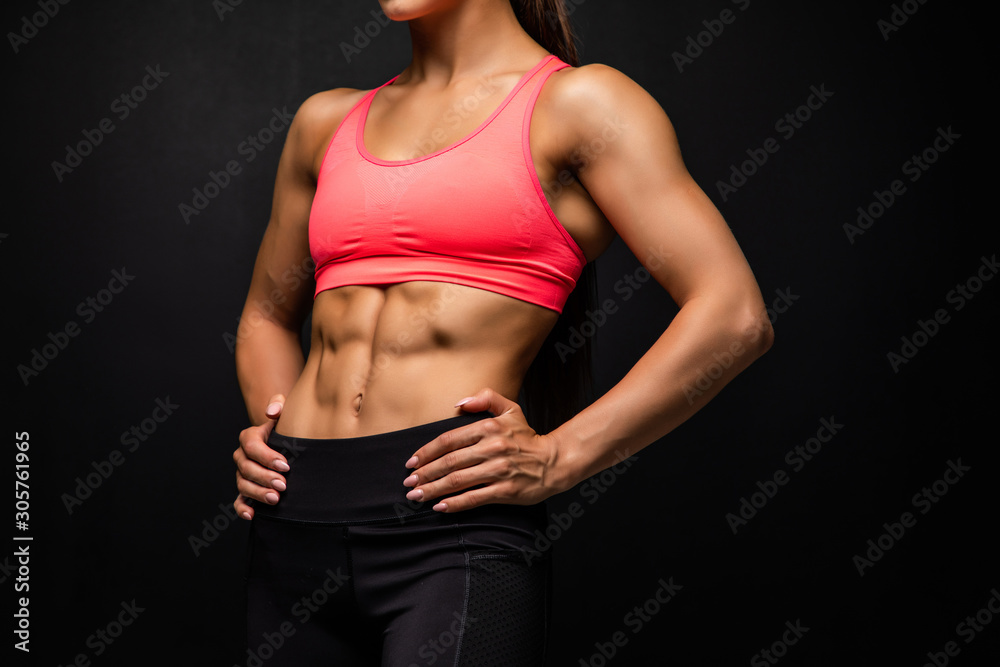 Cropped shot of a beautiful female with fit and toned strong body on black background. - obrazy, fototapety, plakaty 