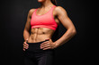 © F8  \ Suport Ukraine - Cropped shot of a beautiful female with fit and toned strong body on black background.