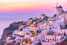 Beautiful View Of Oia Village With Traditional White Architecture And Windmills In Santorini Island In Aegean Sea At Sunset, Greece. Scenic Travel Background.
