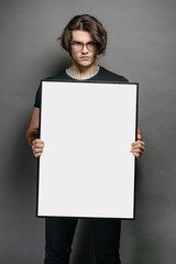 Wall Mural - Man holding a picture frame or poster for mock up wearing black clothes