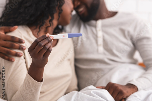 Fotografía Happy african american couple showing pregnancy test with positive result