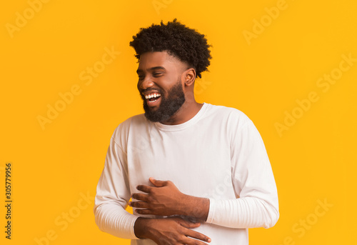 Fotografía Funny african man laughing out loud, holding his belly