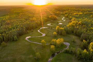 Forest in summer colors. Green deciduous trees and winding blue river in sunset. Mulgi meadow, Estonia, Europe