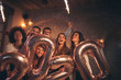 Friends waving with sparklers and holding 2020 balloons celebrating New Year