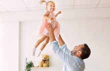 Millennial Dad Throwing Little Girl Up In The Air
