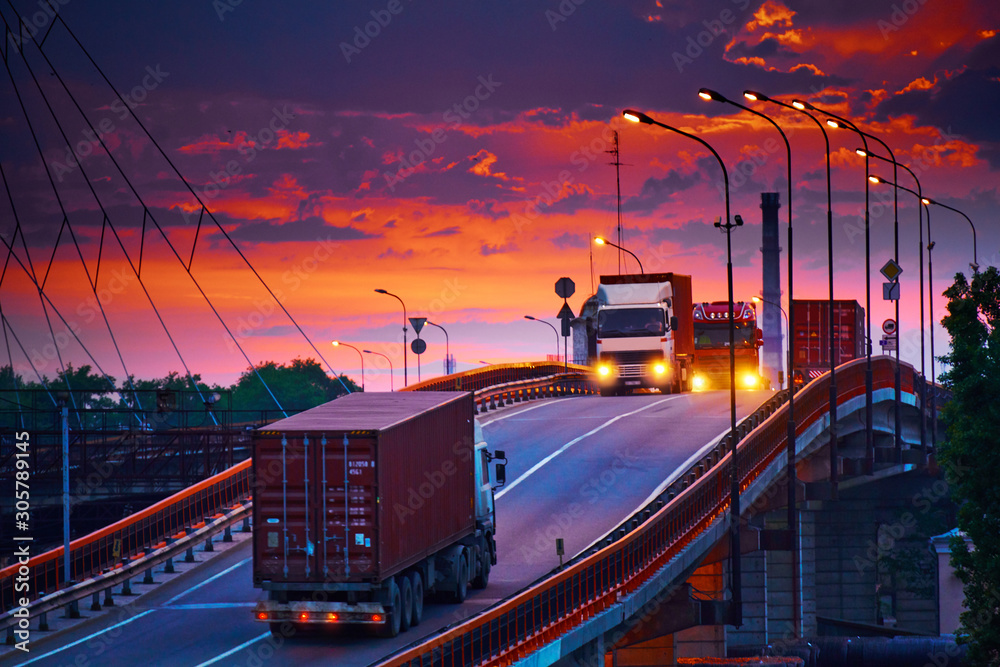 truck with container rides on the road, railroad transportation, freight cars in industrial seaport at sunset - obrazy, fototapety, plakaty 