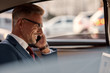 © Svitlana - So happy to hear you. Side view of mature businessman sitting in the car and talking by the phone