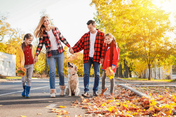 Canvas Print - Happy family with dog walking in autumn park